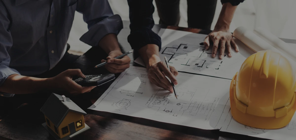 Architects reviewing building plans with hard hat